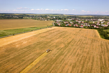 Fototapeta na wymiar Aerial view of combine harvester harvesting large ripe wheat field. Agriculture from drone view