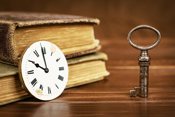 Vintage key with clock and books. Life coaching, motivation, solution concept.
