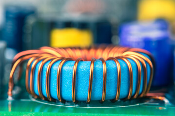 Macro view of electronic component, induction coil with copper wire winding on magnetic ferrite...