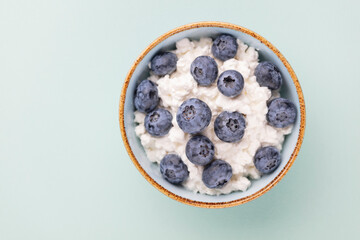 Cottage cheese with blueberry, fresh berries, keto healthy breakfast concept, top view.