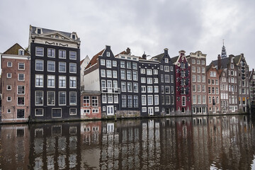 Fototapeta na wymiar Damrak Waterfront: Typical old Dutch houses at Damrak water canal. Amsterdam, Netherlands.