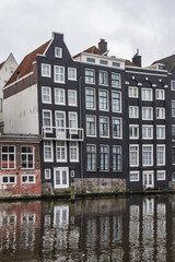 Obraz premium Damrak Waterfront: Typical old Dutch houses at Damrak water canal. Amsterdam, Netherlands.
