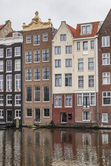 Fototapeta premium Damrak Waterfront: Typical old Dutch houses at Damrak water canal. Amsterdam, Netherlands.