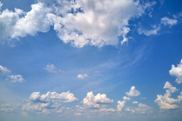 Bright landscape of white puffy cumulus clouds on blue clear sky