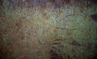 Photo of the texture of a rusty metal wall in green color.The background is made of an old sheet of iron.