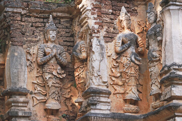 Fototapeta na wymiar Ancient statue on temple wall,Thailand