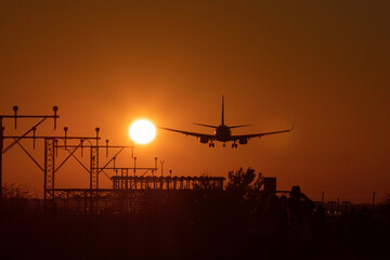 Airplane landing with the sun nearby