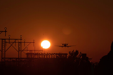 Airplane landing with the sun nearby