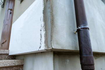Installation of styrofoam insulation sheets on house facade wall for thermal protection