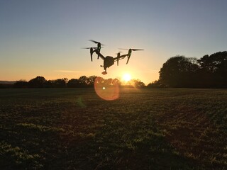 Fototapeta na wymiar silhouette of a drone flying with a sunset sky