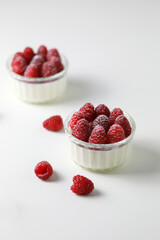 Italian dessert panna cotta with raspberries on white background.