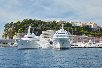 Monaco, Monte-Carlo, two large motor yachts are parked side by side in the port, with huge fenders...