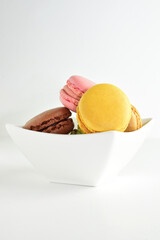 Vertical shot, macarons of assorted flavors, isolated on white background, typical French sweet.