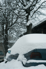 The car is standing in the snow, a photo on the street
