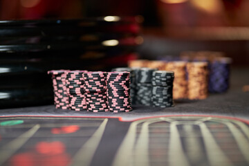 Multicolored casino table with roulette in motion, with multicolored casino chips. multi-colored poker chips. casino chips. online casino, poker, gambling. Gaming table