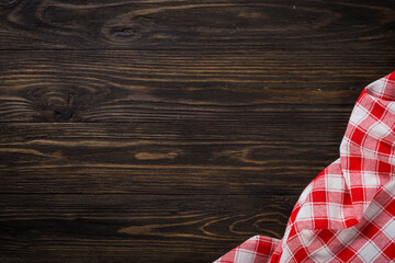 Kitchen table with red plaid tablecloth. Top view copy space on wooden table.