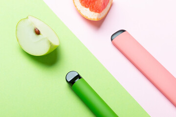 Electronic cigarettes with different fruit flavors with ingredients on colored backgrounds