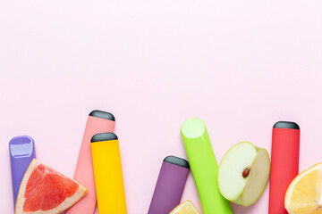 Electronic cigarettes with different fruit flavors with ingredients on colored backgrounds