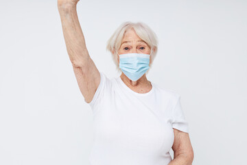 emotional elderly woman respiratory protection light background