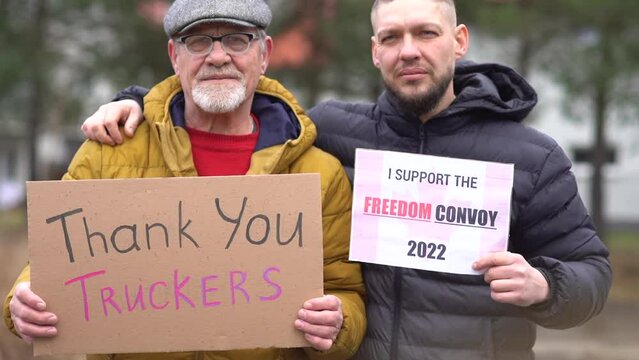 Two men. Portrait of people with posters Thank you truckers and Freedom convoy on every Sunday march against lockdowns and vaccine mandates in a Canada