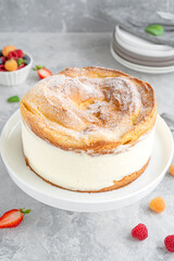 Traditional Polish cake Karpatka on a gray concrete background. Cake of choux pastry dough and custard cream with fresh berries and powdered sugar on top. Carpathian cake. Copy space.
