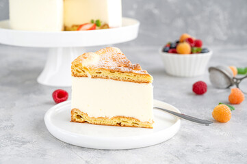 Traditional Polish cake Karpatka on a gray concrete background. Cake of choux pastry dough and custard cream with fresh berries and powdered sugar on top. Carpathian cake. Copy space.
