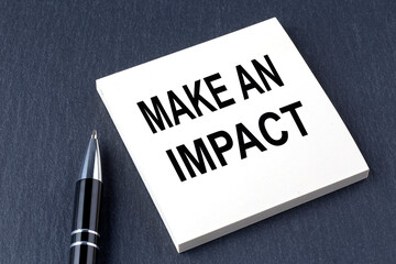 MAKE AN IMPACT text on the sticker with pen on the black background