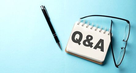 Q and A text written on a notepad on the blue background