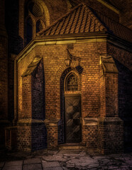 Plakat stary gotycki kościół z cegły pięknie oświetlony nocą