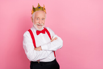 Portrait of attractive cheerful gray-haired man wearing tiara folded arms isolated over pink pastel...