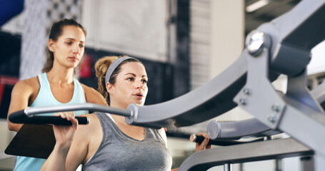 Lets begin.... Cropped shot of a female fitness instructor taking her client through a workout in...