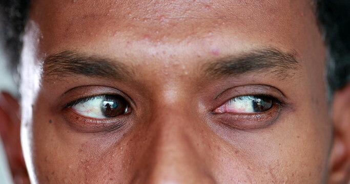Pensive african american descent close-up eyes macro. Thoughtful Closeup black person eye looking up thinking