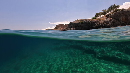 Fototapeta na wymiar Underwater split photo of small bay and pituresque village of Avlemonas with emerald crystal clear sea in island of Kythira, Ionian, Greece