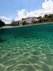 Underwater split photo of small bay and pituresque village of Avlemonas with emerald crystal clear sea in island of Kythira, Ionian, Greece