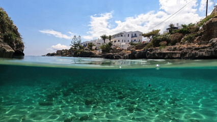 Underwater split photo of small bay and pituresque village of Avlemonas with emerald crystal clear sea in island of Kythira, Ionian, Greece