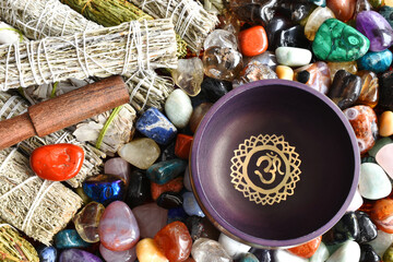 A top view image of a purple meditations singing bowl with white sage smudge sticks and healing...