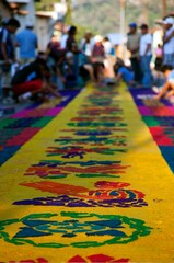 Street screen of locals producing alfombra, sawdust carpets with colorful designs for Semana Santa, Easter on the streets of Lake Atitilan, Guatemala.