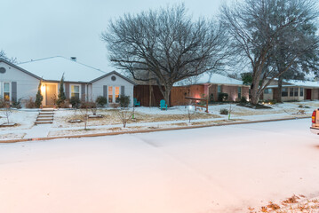 Wintertime quiet residential street covered in snow and ice with light poles in suburbs Dallas, Texas, America