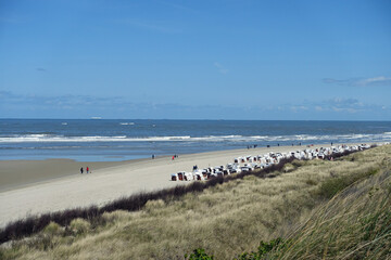 Fototapeta na wymiar Strand mit Strandkörben und Spaziergängern auf Spiekeroog