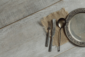 Vintage cutlery fork, knife, spoon, tray on a gray wooden background. Top view, natural light with copy space