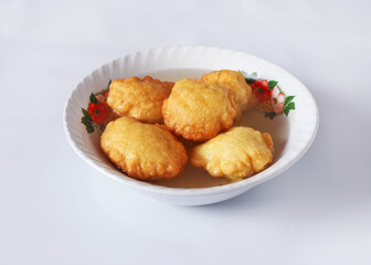 GUATEMALAN BUÑUELOS MADE OF FRIED DOUGH AND PLACED IN A PLATE FILLED WITH A SPECIAL HONEY LIQUID 