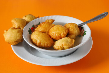 GUATEMALAN BUÑUELOS MADE OF FRIED DOUGH AND PLACED IN A PLATE FILLED WITH A SPECIAL HONEY LIQUID 