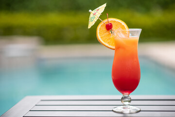 a cocktail glass by the pool on the right side - Powered by Adobe