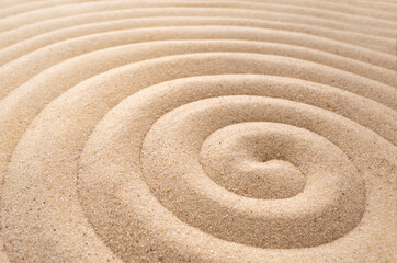 Fototapeta na wymiar The concept of summer, rest. top view of a sandy background with dunes. The Zen concept. A spiral drawn in the sand