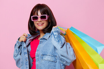 woman in denim jackets with colorful shopping bags isolated background