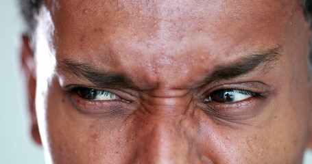 African man eyes squinting. Close-up black guy closing eyes squint