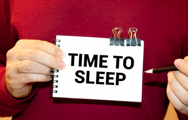 man holding a sign saying time to sleep