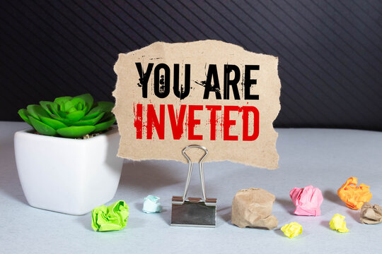 YOU ARE INVETED. text on white notepad paper. near torn blue paper