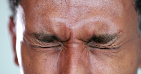 African man eyes squinting. Close-up black guy closing eyes squint