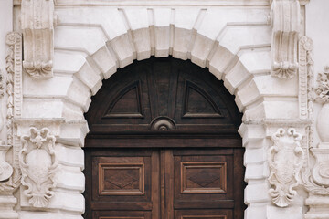 The upper part of the doorway of the old baroque style with a complex design of the facade. The facade of the building with relief in Lviv (Ukraine).
